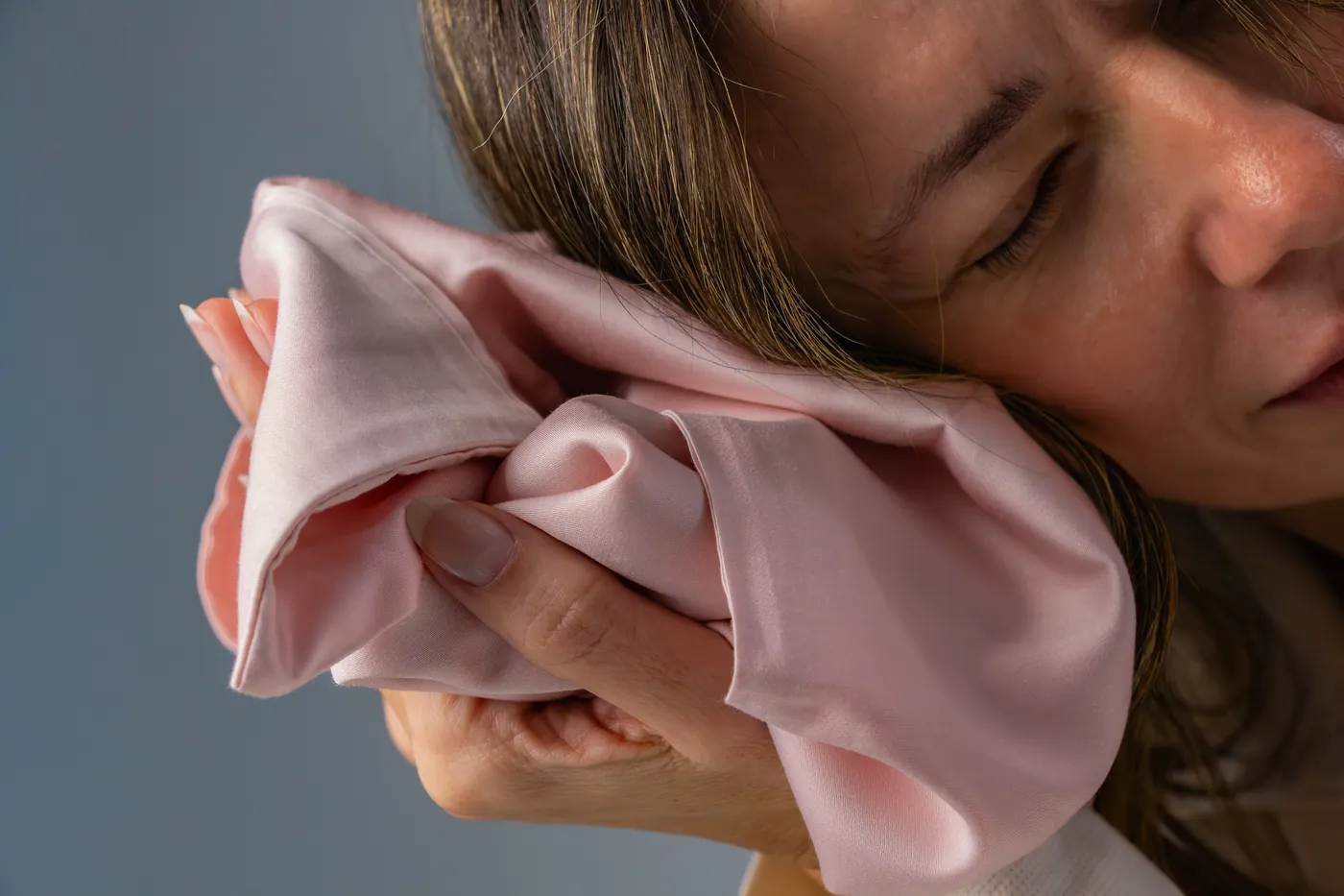 Mulher sentindo a maciez do lençol Rosé